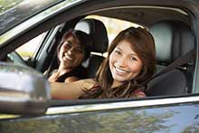 Two drivers smiling in a car